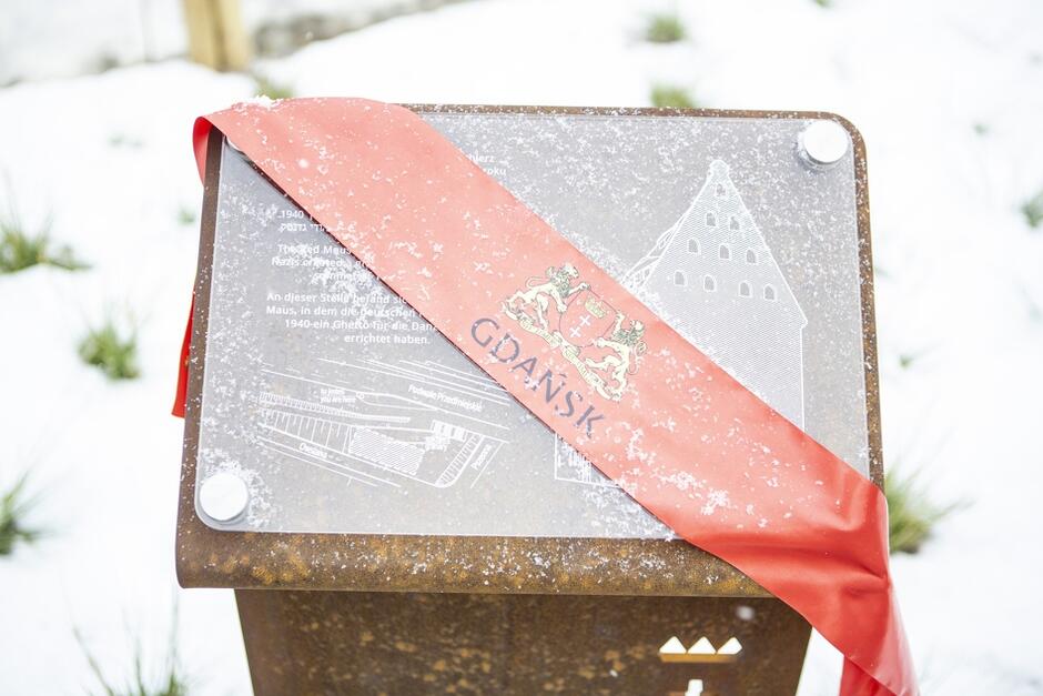 nowa tablica z czerwoną wstęgą z napisem GDAŃSK