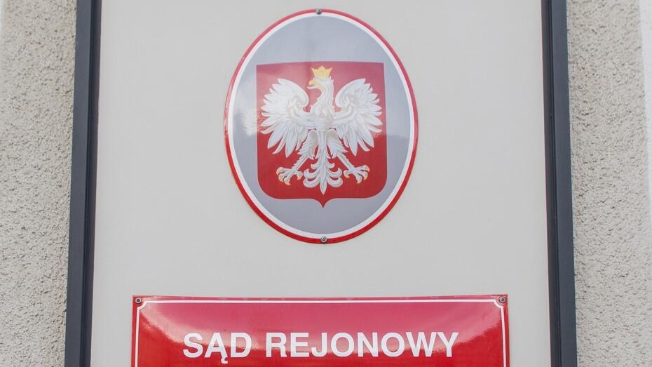 Dwie tabliczki na ścianie budynku. Górna jest owalna, z godłem Polski. Na dolnej, prostokątnej, jest napis: Sąd Rejonowy 