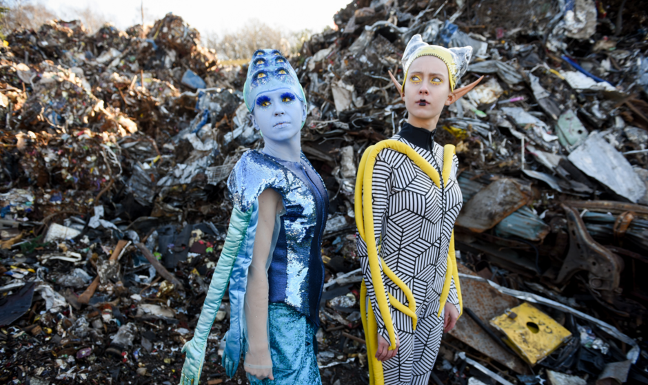 dwie aktorki przebrane za kosmitki w scenerii wysypiska śmieci