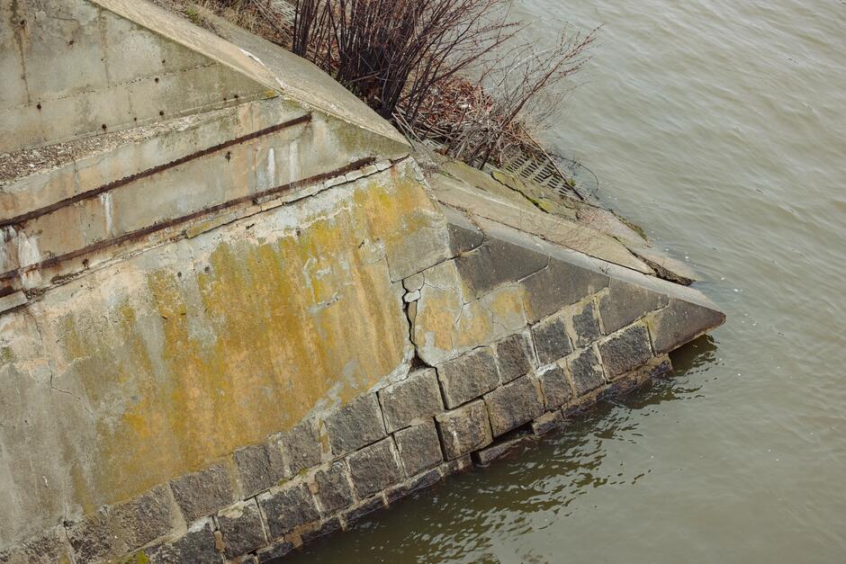Zdjęcie fundamentów przyczółka mostu, widoczne część znajduje się tuż nad wodą 