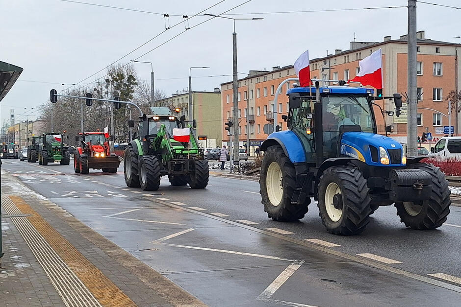 Ciągniki rolnicze jadą ulicą przez miasto