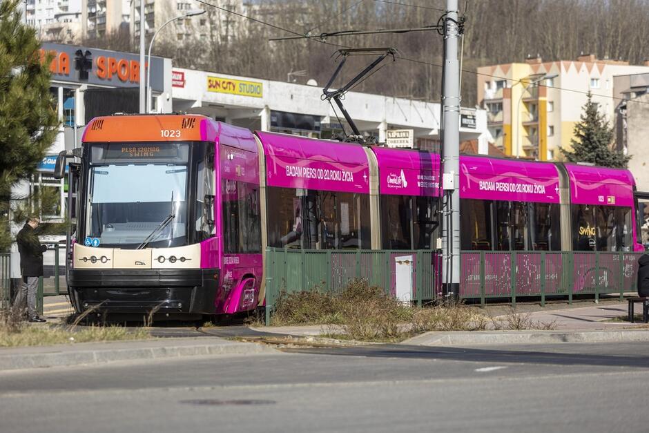 oklejony na różowo tramwaj na torach