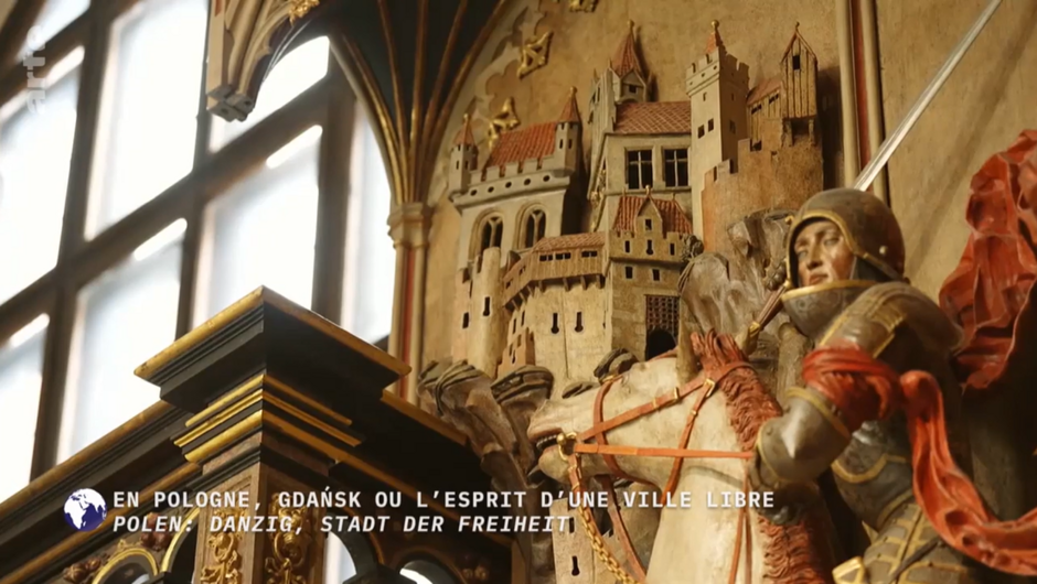 drewniana, malowana płaskorzeźba przedstawiająca rycerza na koniu oraz fragment prawdopodobnie średniowiecznego miasta