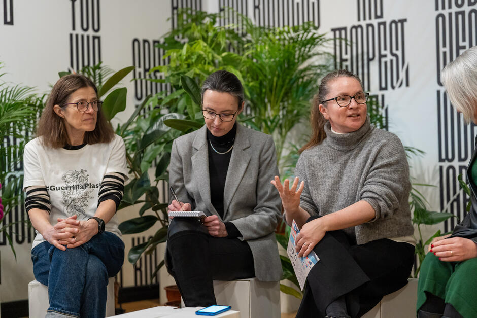 trzy kobiety siedzą podczas konferencji w luźnej atmosferze, jedna z nich mówi