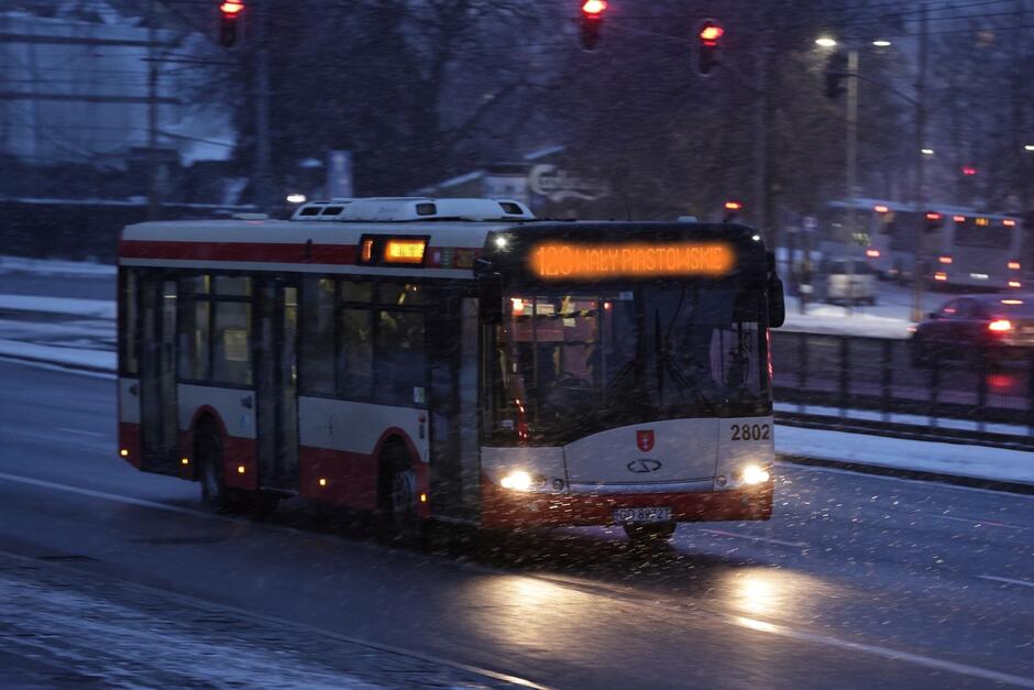 Zdjęcie autobusu jadącego w porze nocnej ulicą miasta