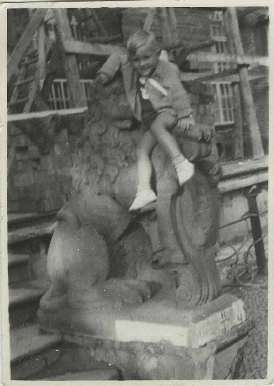 Cłopczyk, w wieku około 2 lat, na kamiennym lwie przedproża Dworu Artusa w Gdańsku