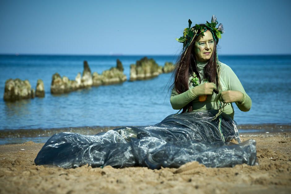 aktorka w stroju syreny siedzi na plaży