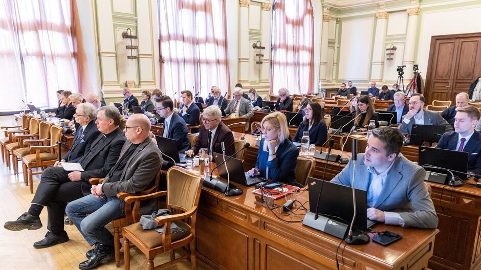 Zdjęcie przedstawia radnych w czasie obrad w sali plenarnej Rady Miasta Gdańska