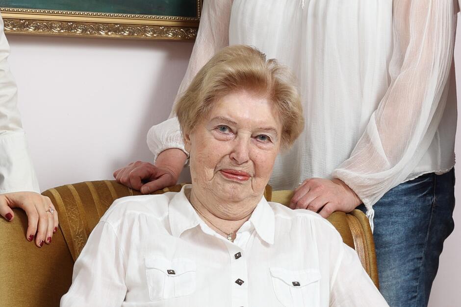 Zdjęcie uśmiechniętej kobiety w wieku lat około 80, w białej bluzce, o krótkich blond włosach