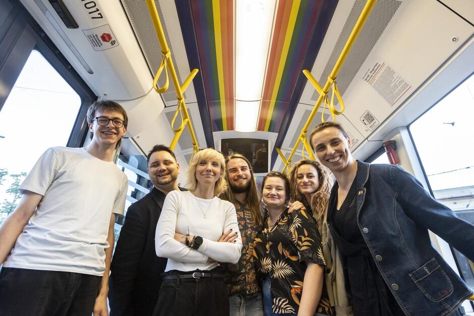 Pięć osób pozuje do zdjęcia we wnętrzu tramwaju