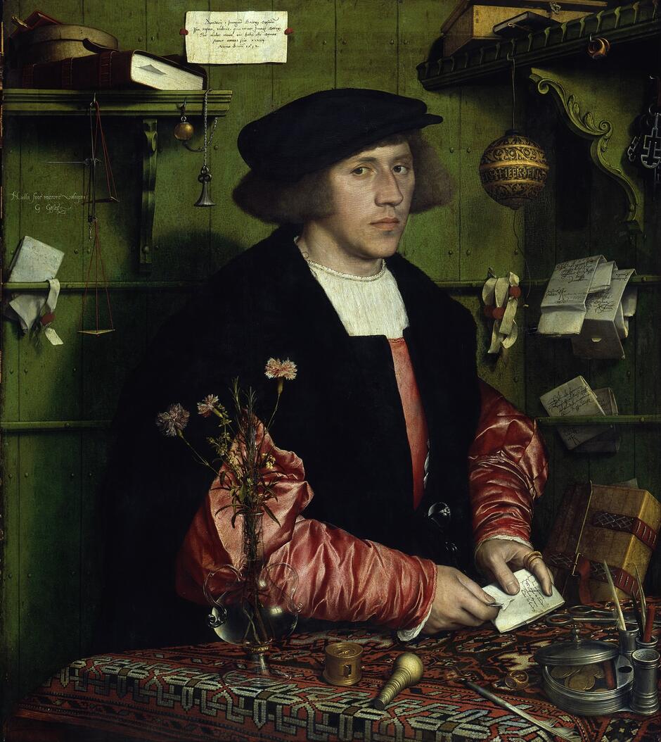 Obraz przedstawia portret kupca gdańskiego Georga Giesego w jego kantorze hanzeatyckim w Londynie, namalowany przez Hansa Holbeina młodszego w 1532 roku. Mężczyzna ubrany w czarny płaszcz z czerwonymi rękawami siedzi przy stole, na którym znajdują się różne przedmioty handlowe, dokumenty oraz wazon z kwiatami, a w tle widać półki z książkami i innymi przedmiotami.