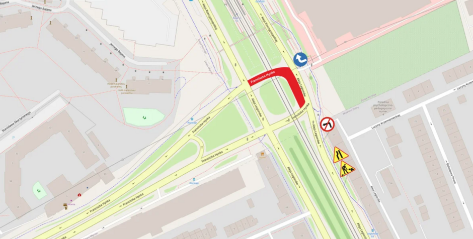 Na zdjęciu widoczna jest mapa drogowa przedstawiająca fragment miejskiej infrastruktury. Centralnym elementem mapy jest skrzyżowanie ulic Franciszka Hynka oraz Alei Rzeczypospolitej w Gdańsku. Mapa zawiera zaznaczoną czerwoną linię, która oznacza zamknięty odcinek drogi. W prawym dolnym rogu widoczne są znaki drogowe informujące o zakazie skrętu w lewo oraz znaki ostrzegawcze dotyczące robót drogowych.