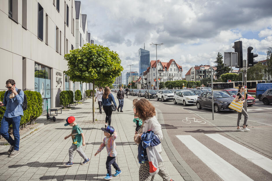 Baner: strategia rozwoju miasta Gdańsk 2030 Plus, czerwone tło i panorama Gdańska