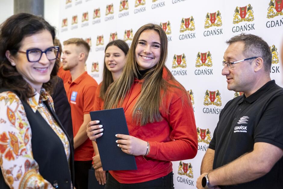 ludzie stoją w szeregu, odbierają gratulacje 