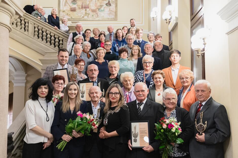 zdjęcie grupowe, pamiątkowe, na zabytkowych schodach stoi około czterdziestu osób, w kilku rzędach, pozują do zdjęcia