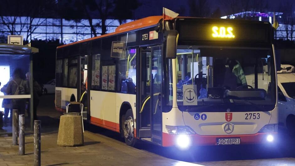 Noc: autobus na przystanku, na wyświetlaczu nad szybą czołową jest napis: SOS