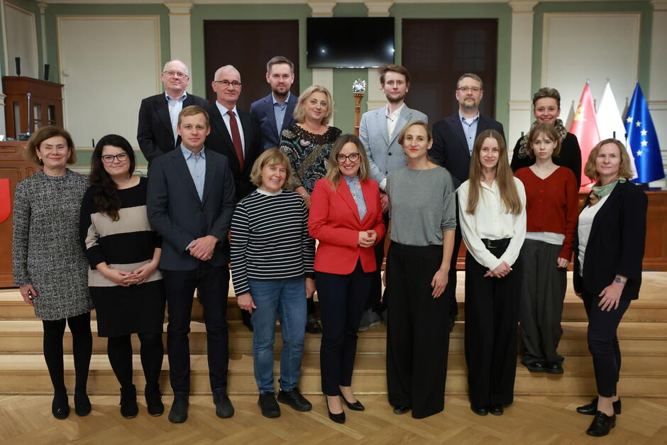 na zdjęciu grupa około dwudziestu osób, pozują do zdjęcia stojąc na schodach w dwóch rzędach