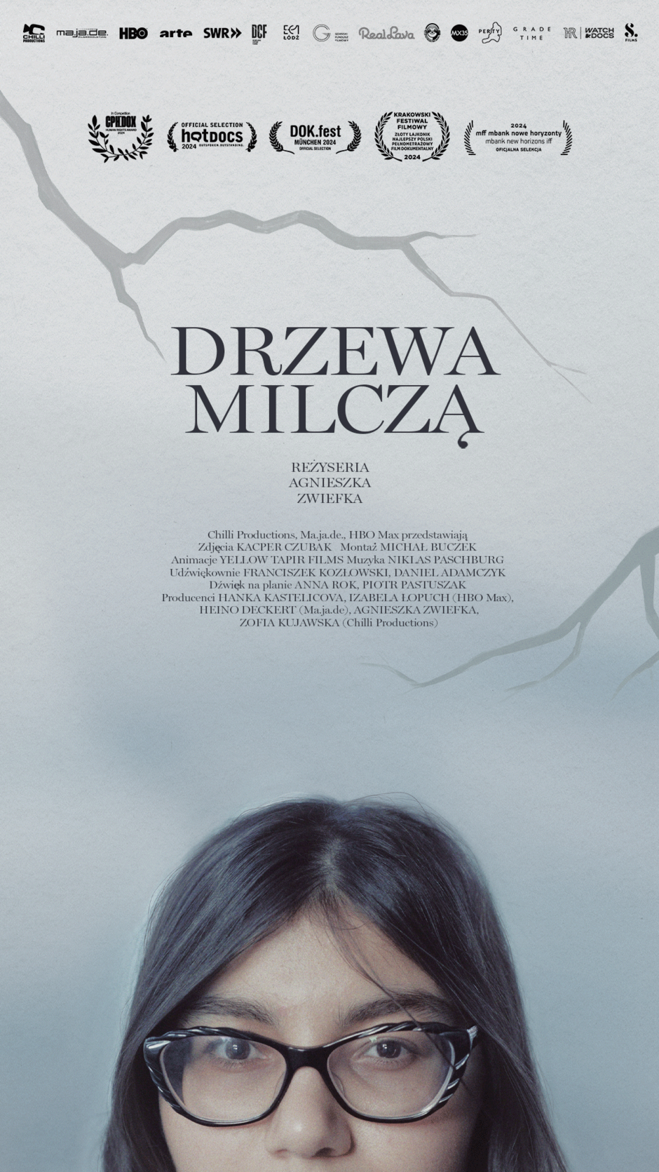 Plakat przedstawia fragment twarzy kobiety w okularach, skierowaną wprost na widza, a na górze widnieje tytuł filmu DRZEWA MILCZĄ  oraz nazwisko reżyserki, Agnieszki Zwiefki. Na plakacie znajdują się także informacje o produkcji oraz laury festiwalowe