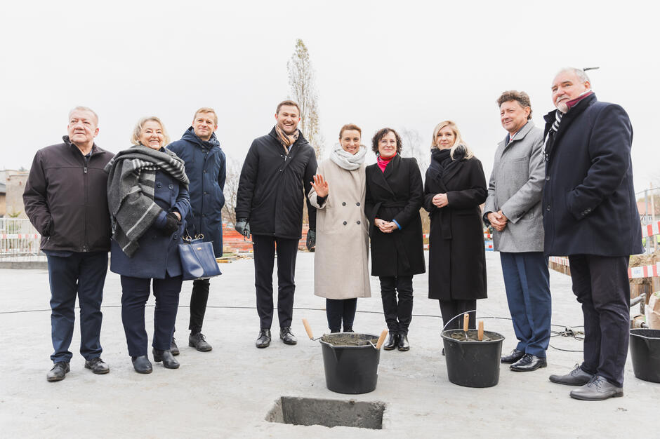 na zdjęciu dziesięć osób w zimowych ubraniach, stoją w rzędzie, pozują do zdjęcia