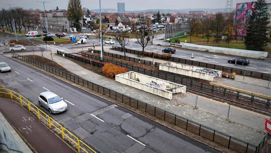 Zdjęcie z lotu ptaka. Dwupasmowa ulica ze starym zejściem do tunelu, gdzie było przejście podziemne. Obok nowe przejście naziemne.