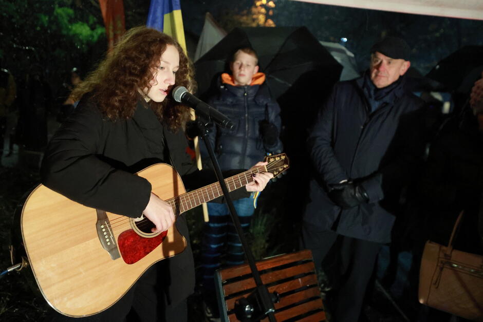 kobieta śpiewa i gra na gitarze 