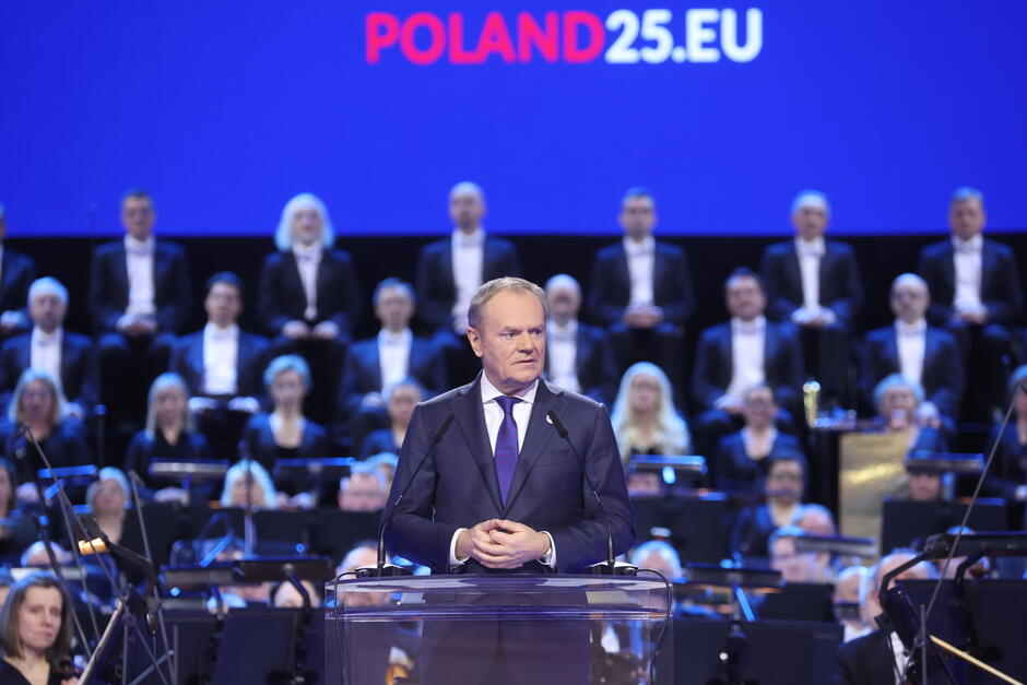 na zdjęciu premier donald tusk w granatowym garniturze, przemawia do mikrofonu