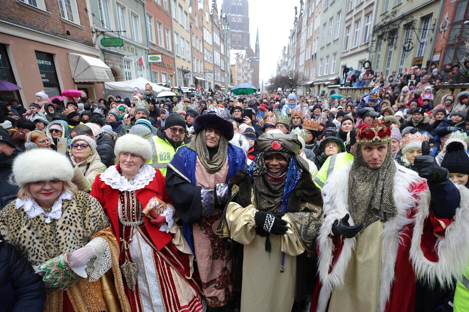 Parada, barwny tłum ludzi, na pierwszym planie królowie i inni przebierańcy 