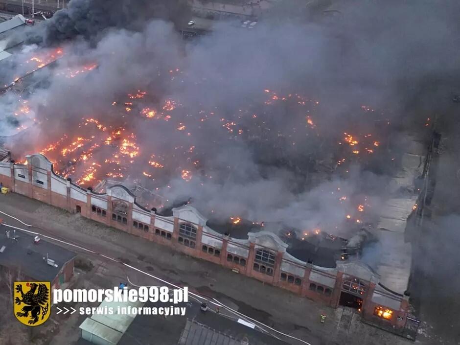 Pokazany z drona widok dopalającego się wnętrza hali na Przeróbce