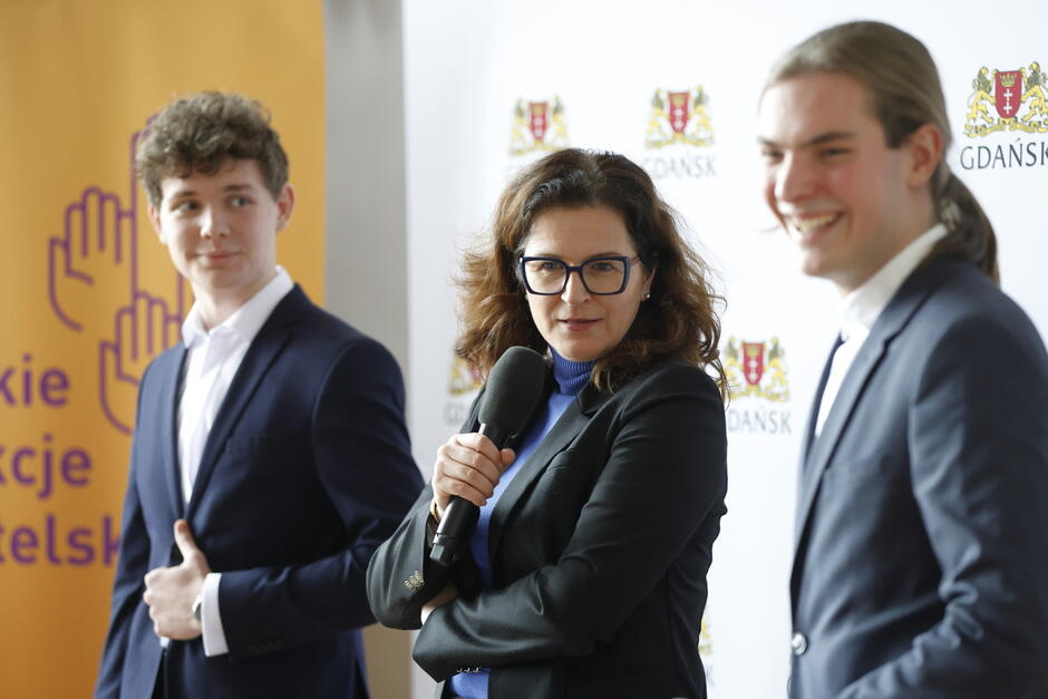 trzy osoby prowadzą spotkanie