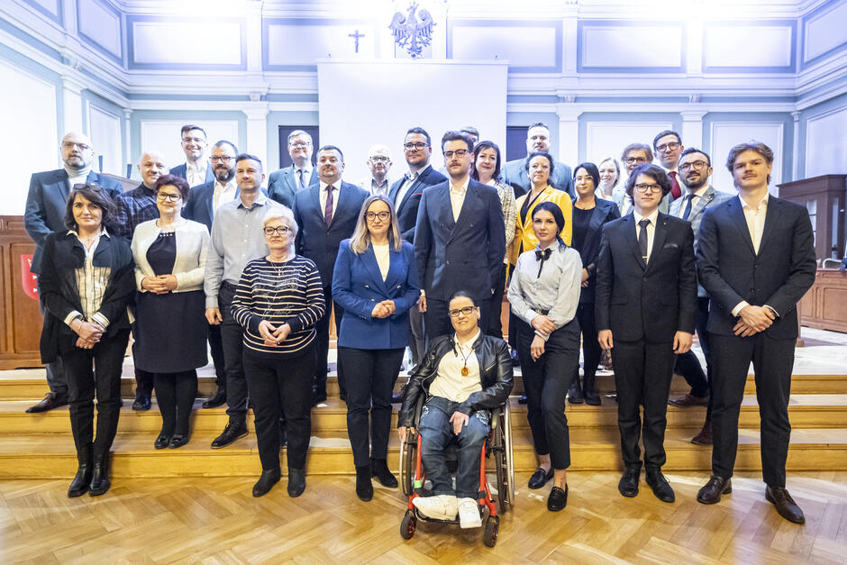 zdjęcie grupowe, pozuje ponad dwadzieścia osób ustawionych w trzech rzędach