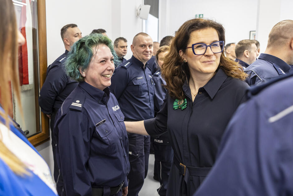 Prezydent Gdańska po prawej w rozmowie z jedną z nagrodzonych policjantek - po lewej. Wokół i w tle - inni policjanci