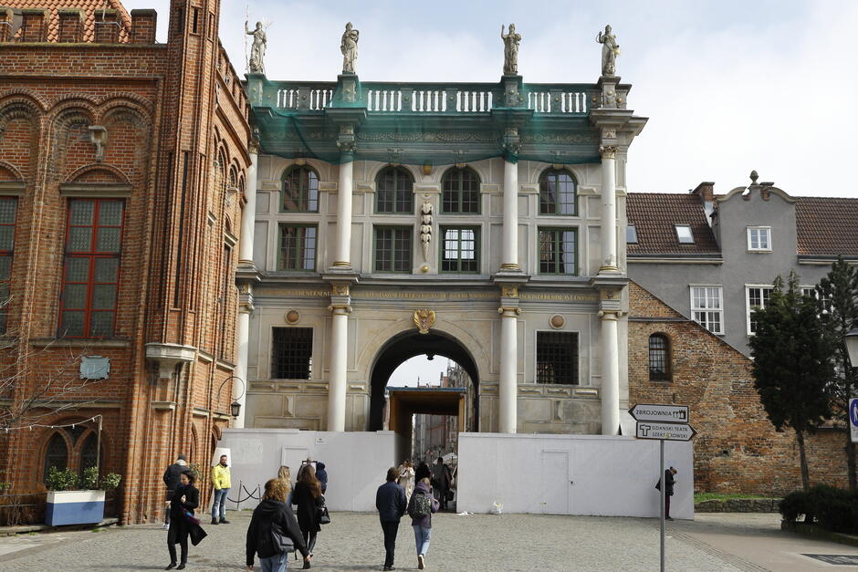 na zdjęciu zabytkowa złota brama gdańska, częściowo ogrodzona 