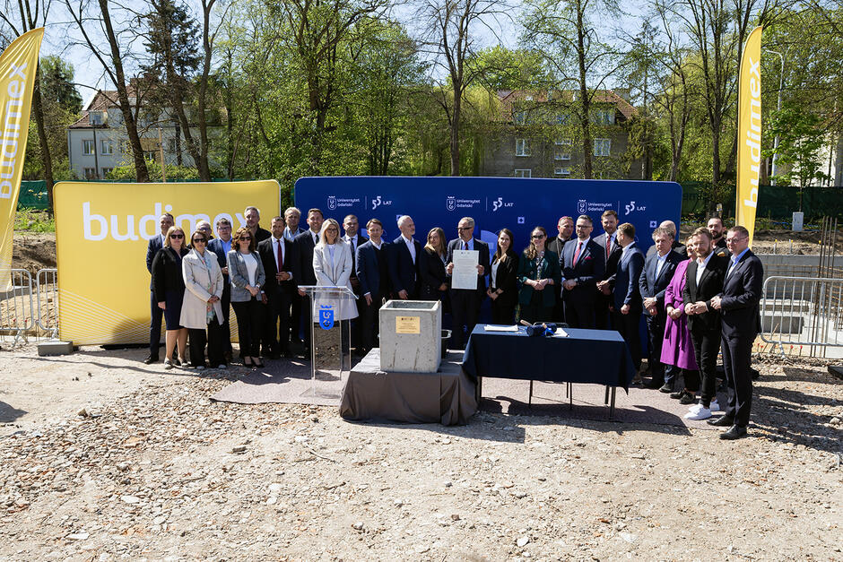 Grupa ludzi pozuje do zdjęcia podczas uroczystości wmurowania kamienia węgielnego pod budowę centrum Sportowego Uniwersytetu Gdańskiego.