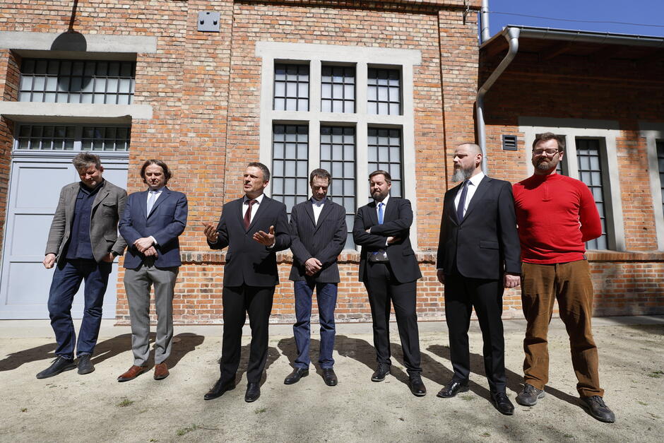 ludzie przed budynkiem z cegły