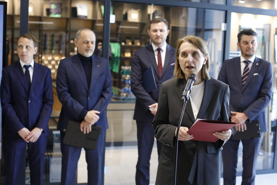 ludzie w rzędzie, przemawia kobieta