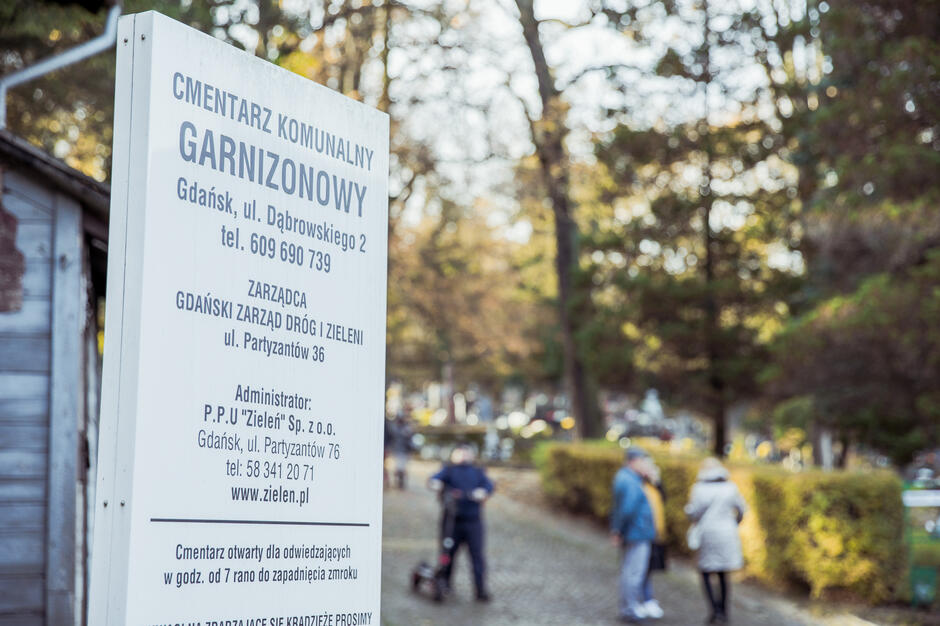 brama wejściowa na cmentarz z tablicą informacyjną