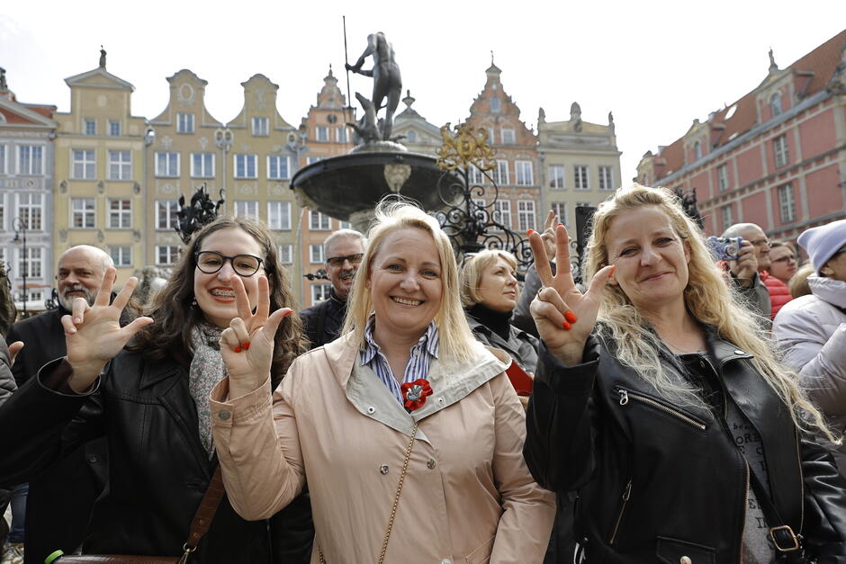 Kilka osób pod fontanną Neptuna. Składają przysięgę, trzymając w uroczystym geście palce podniesionej prawej ręki 