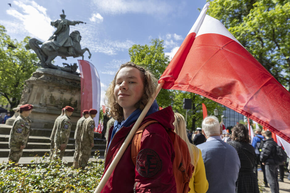 Nastolatek z biało-czerwoną flagą na ramieniu