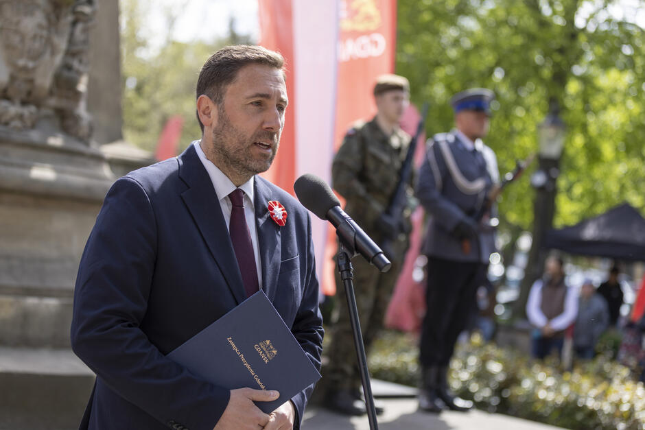 Mężczyzna w średnim wieku, przemawia na uroczystości