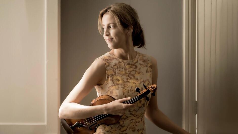 Na zdjęciu widzimy skrzypaczkę Vilde Frang w nastrojowym ujęciu z instrumentem w dłoniach