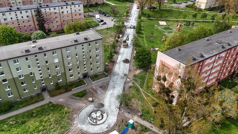 zdjęcie z drona, widać remontowaną ulicę osiedlową, wokół niej stoją bloki mieszkalne