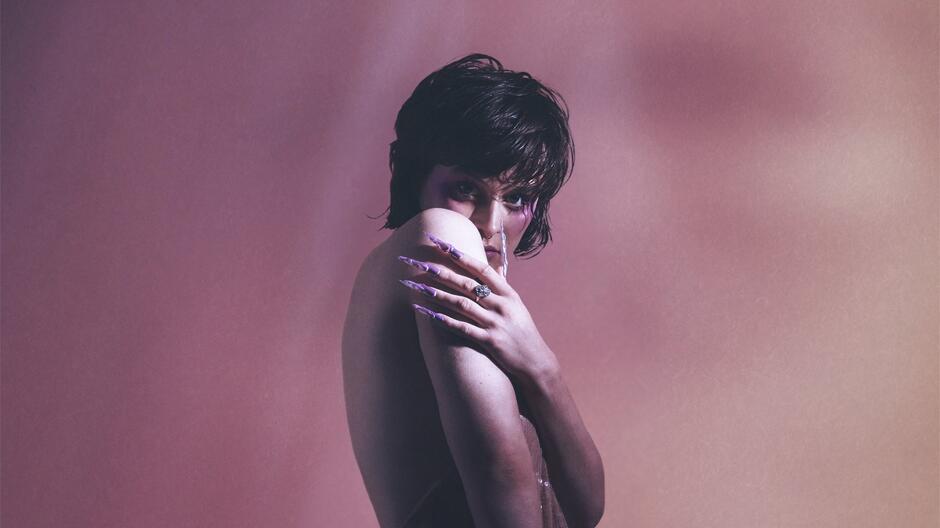 Na zdjęciu prawy profil kobiety o ciemnych, krótkich włosach, o nagim ciele, z ukrytymi częściami intymnymi.