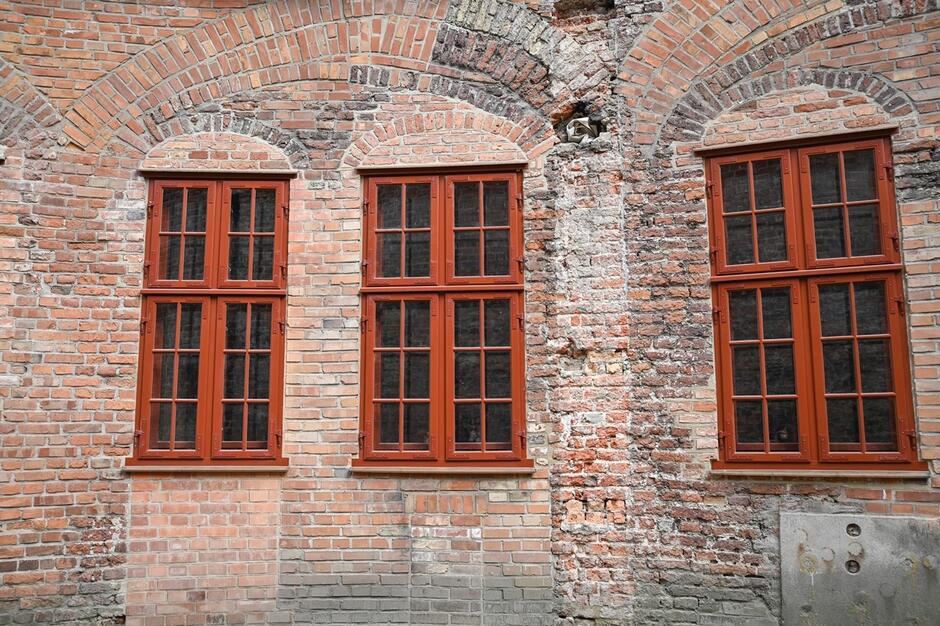 Mur ze starej cegły i odnowione zabytkowe okna