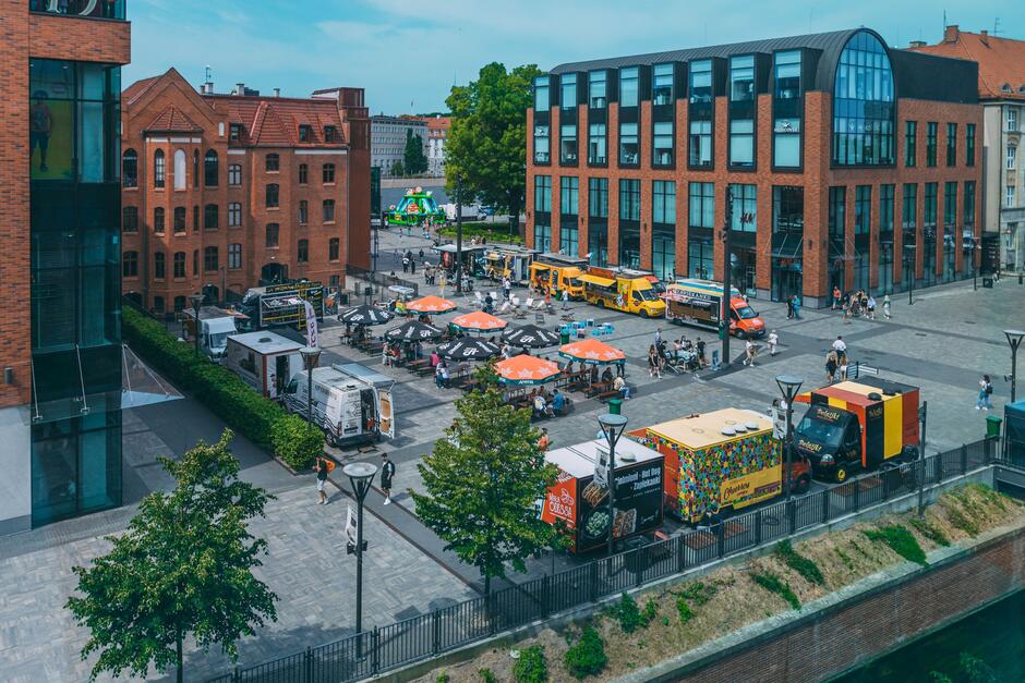 Na zdjęciu widzimy strefę food trucków przy Forum Gdańsk, popularnym centrum handlowym i rozrywkowym w Gdańsku.