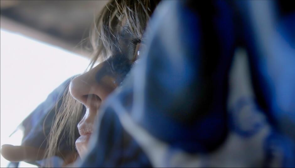 Na zdjęciu twarz kobiety pomalowana na niebiesko.