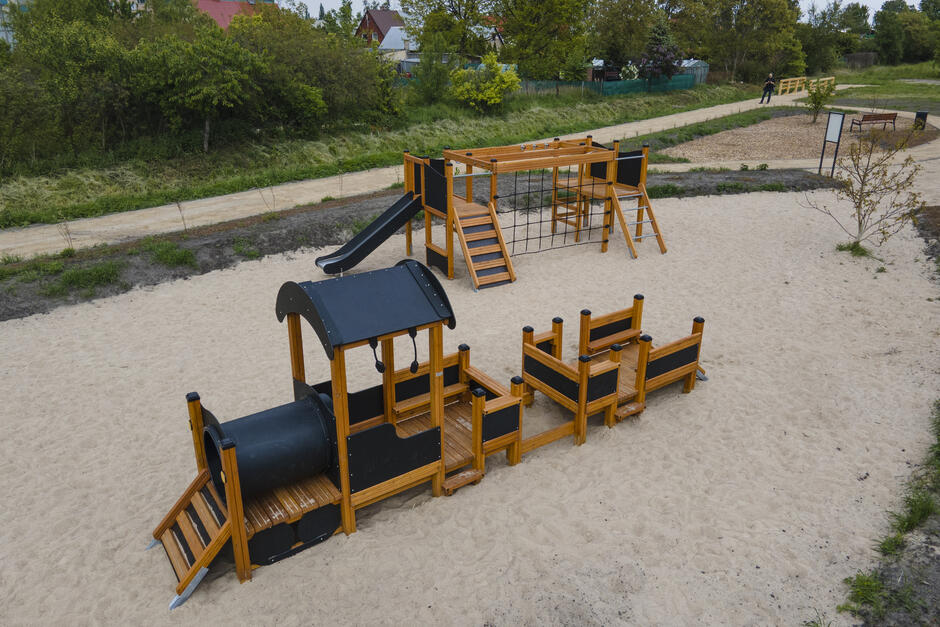 na zdjęciu plac zabaw, wśród urządzeń widać jedno przypominające lokomotywę pociągu