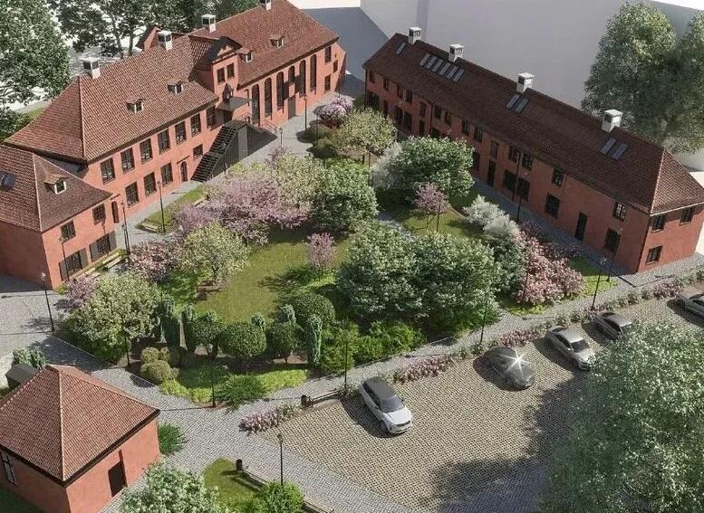 Na zdjęciu widzimy odnowiony kompleks budynków o charakterze historycznym, prawdopodobnie dawny sierociniec lub inny obiekt użyteczności publicznej, który został przekształcony w nowoczesne miejsce mieszkalne lub kulturalne. Budynki wykonane są z czerwonej cegły, z dachami pokrytymi dachówką ceramiczną. Całość tworzy zamknięty dziedziniec w kształcie litery „U”.