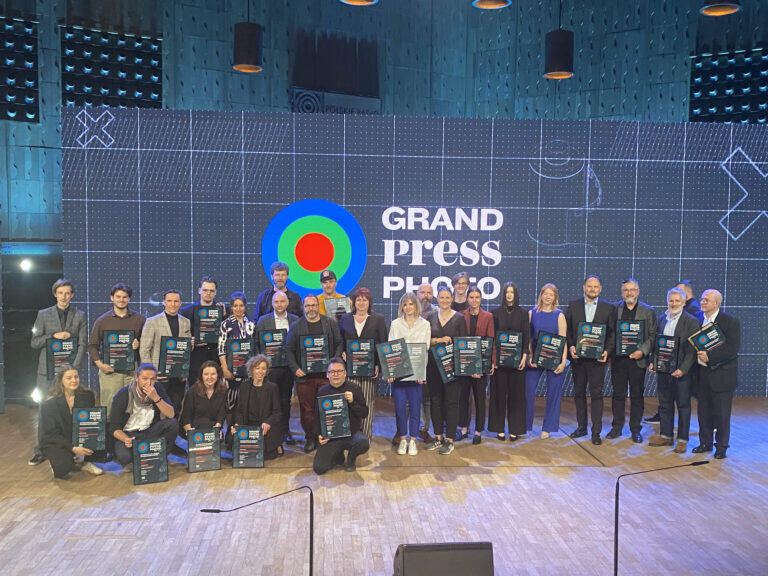 Grupa około 25 osób z dyplomami, na scenie