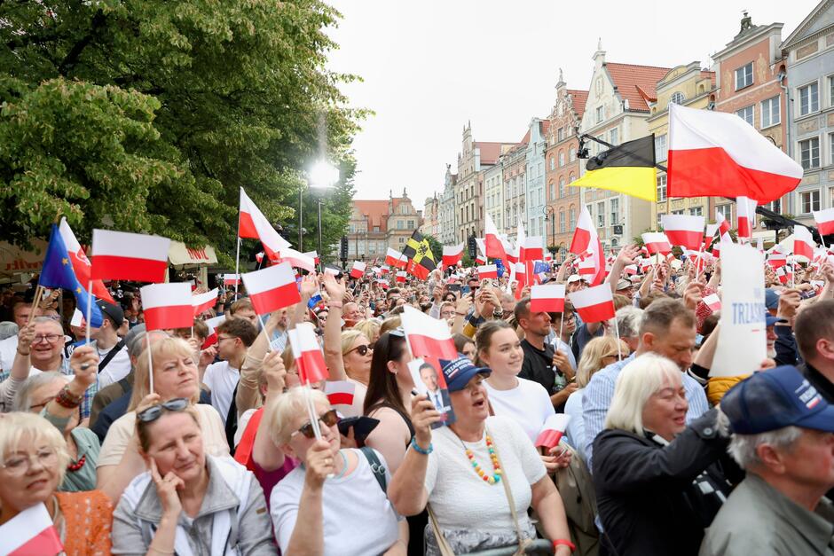 To drugie zdjęcie również przedstawia wiec polityczny w Polsce, z wyraźnym poparciem dla Rafała Trzaskowskiego — świadczą o tym trzymane przez uczestników plansze z jego imieniem i nazwiskiem.