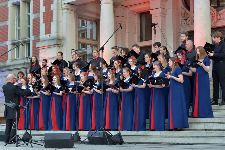 chórzyści podczas występu na dziedzińcu